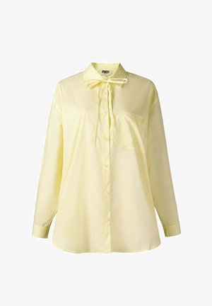 Lichtgele blouse met lange mouwen, knoopsluiting aan de voorkant, borstzak, kraag en een gestrikte strik bij de hals, afgebeeld op een witte achtergrond.