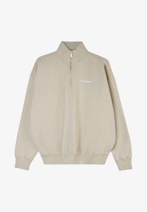 Bež pullover kõrge kaelusega, poolsahtli sulgemise ja soonikute kõrvaotsadega. Pehme kangas, mille ees on valge "PEGADOR" logo trükitud.