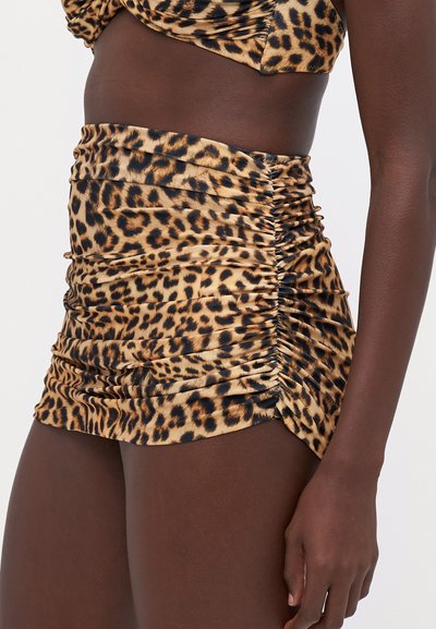 Leopardprint minirok met ruches en een strakke pasvorm, gemaakt van zacht, glanzend materiaal en met geplooide details langs de zijkanten voor textuur.