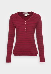 Röd långärmad topp med horisontella ränder, V-ringning, sex knappdetaljer och rynkad nederkant för en åtsittande look. Mjuk tygkänsla.