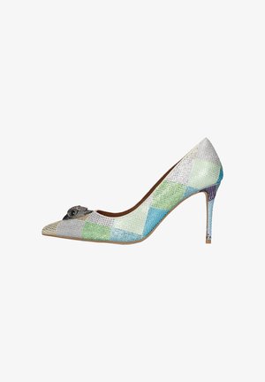 Zapato de tacón alto y punta afilada con un patrón de patchwork en colores pastel y pequeños adornos, que presenta un detalle decorativo metálico en la punta.