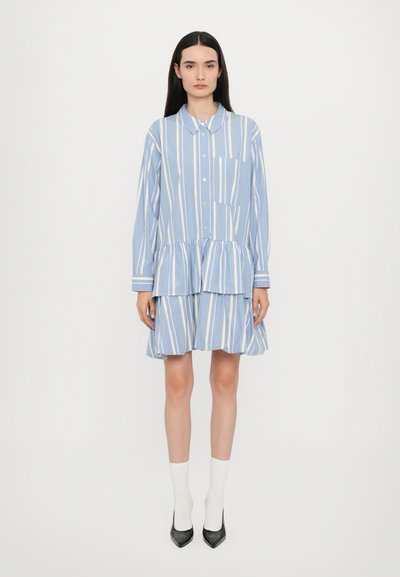 Robe chemise rayée bleu et blanc avec un col, devant à boutons et ourlet en volants à niveaux. Manches longues et poches latérales.