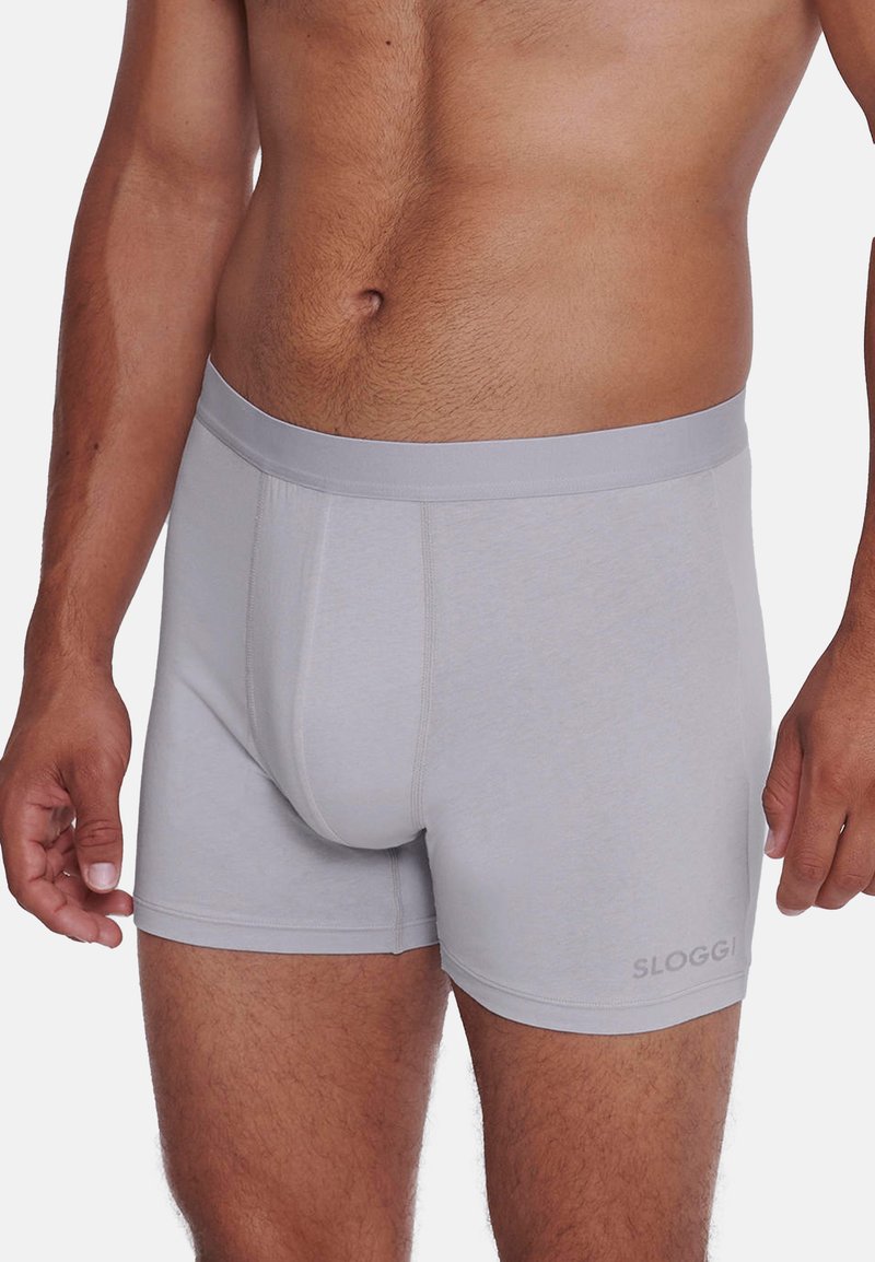Boxer grigi da uomo realizzati in tessuto morbido. Presentano una cintura elastica liscia e una silhouette aderente, con un logo discreto sul lato.