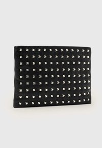 Czarna skórzana kopertówka o płaskim kształcie, z srebrnymi ćwiekami w kształcie piramid ułożonymi w siatkę na przedniej powierzchni.