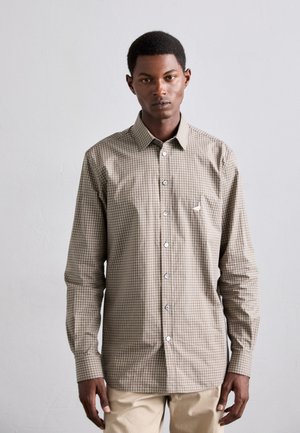 Button-up shirt in brown and tan gingham pattern, with long sleeves and a spread collar. Features white buttons and a small logo on the chest.