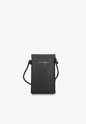 Borsetta in pelle nera con texture, dotata di una tracolla sottile, logo dorato e un design a forma di cuore traforato sul davanti.