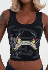 Sort crop top med grafisk design af farverige fugle og teksten "ED HARDY," udsmykket med rhinsten og en tætsiddende pasform.