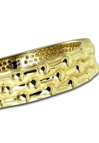 Bracelet métallique doré présentant des motifs texturés avec des détails hexagonaux et sphériques, affichant une surface lisse et réfléchissante.