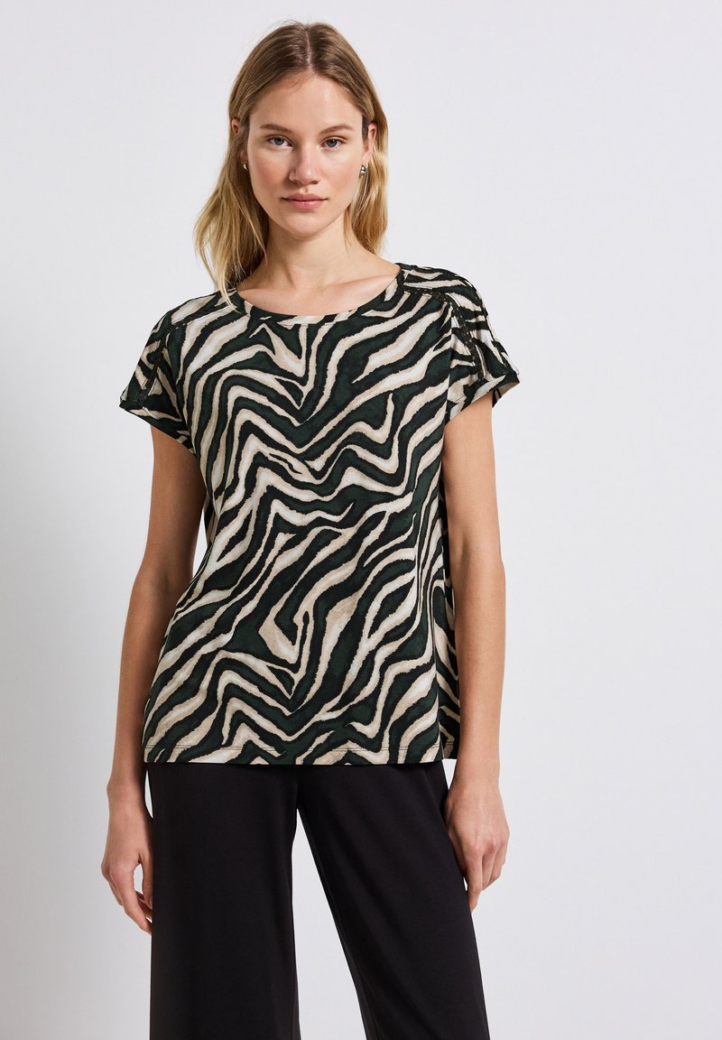 Kortärmad topp i grön och beige zebramönster, tillverkad av lättviktig tyg. Har rundad halsringning och rynkad axeldetalj.
