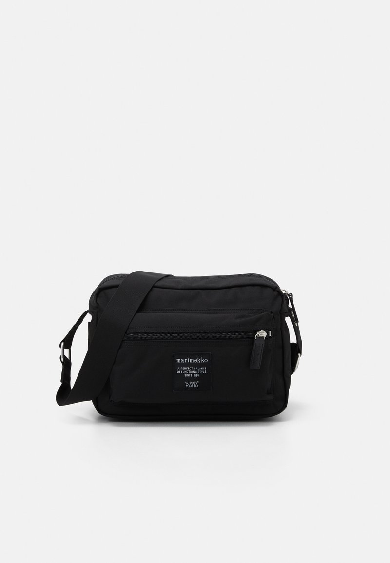 Schwarze Stoff-Schultertasche in rechteckiger Form, mit einem Reißverschluss an der Oberseite, einer Fronttasche, einem verstellbaren Tragegurt und einem Logo-Emblem.
