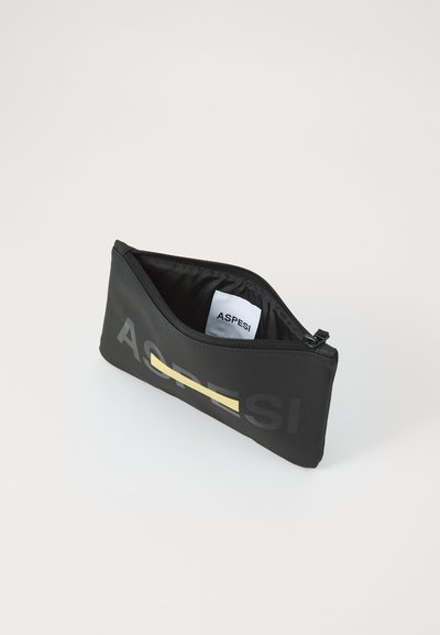 Black pouch with a textured surface, featuring a horizontal yellow stripe. Zip closure and interior tag visible. Large logo on the front.