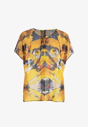 Blouse à manches courtes en tissu transparent présentant un motif abstrait aux teintes vives de jaune, bleu et noir, avec une coupe décontractée et un col rond.