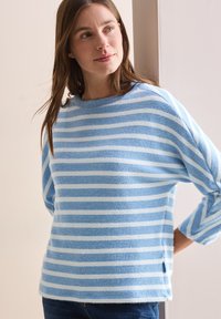 Pull rayé bleu et blanc, fabriqué en matériau doux, avec un col arrondi, des manches longues et des fentes sur les côtés à l'ourlet.