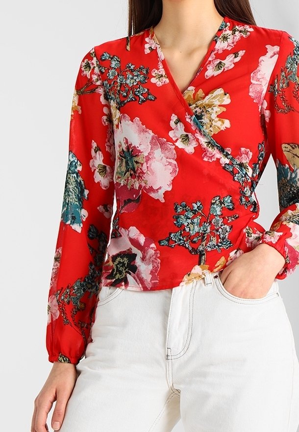 Blusa rossa floreale con maniche lunghe, design avvolgente, caratterizzata da grandi fiori rosa e teal. Realizzata in tessuto leggero con una texture liscia.