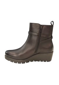 Stivale nero alla caviglia con tacco a zeppa, materiale in pelle liscia, cerniera laterale e un anello sul retro per facilitarne l'indossamento.