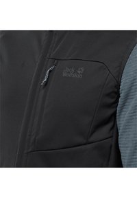 Black and gray jacket with a textured fabric, featuring a zippered chest pocket and the "Jack Wolfskin" logo on the front.