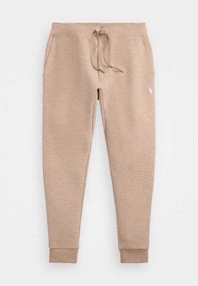 Beige sweatpants made of soft fabric, featuring an elastic waistband with drawstring, side pockets, and tapered cuffs at the ankles.