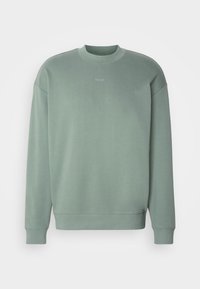 Felpa verde con collo rotondo, maniche lunghe e piccolo logo "HUGO" centrato sul petto, visualizzata su uno sfondo bianco.