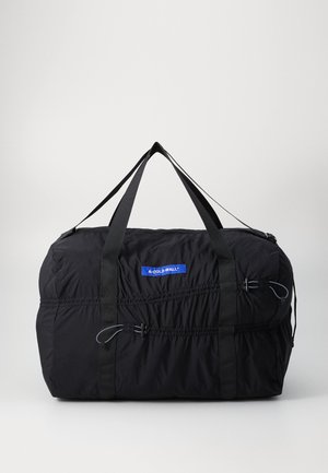 Black duffel bag made of lightweight fabric, featuring adjustable straps, cinched sides, and a blue brand label on the front.