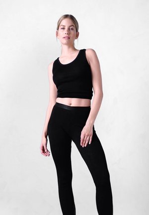 Sort tætsiddende tanktop og leggings lavet af et glat, strækbart stof. Toppen har en rund halsudskæring, og leggingsne har en høj talje.