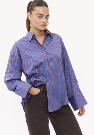 Camisa de rayas azules con líneas verticales naranjas, con botones al frente y mangas largas. Hecha de una tela suave, presenta un corte relajado.
