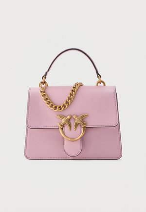 Geantă din piele roz cu închidere aurie în formă de pasăre și detalii de lanț aurii asortate, având un mâner superior, pe fundal alb.