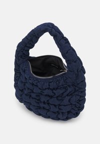 Sac à main en tissu bleu marine froncé avec une poignée rembourrée et une fermeture éclair argentée, partiellement ouvert montrant la doublure intérieure noire.