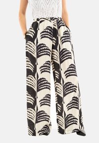 Pantalones de pierna ancha en tejido ligero con un patrón de hojas de palma en blanco y negro. Presentan una cintura elástica y bolsillos laterales.