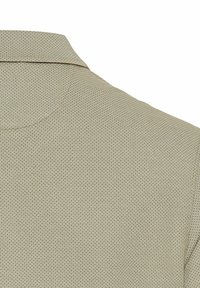 Lysbrun tekstureret polo skjorte med krave og et subtilt geometrisk mønster i hele stoffet.
