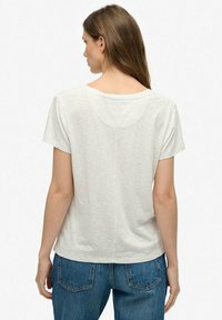 Hellgraues, kurzärmeliges T-Shirt mit lockerer Passform, Rundhalsausschnitt und weicher Textur, kombiniert mit blauen Jeans.