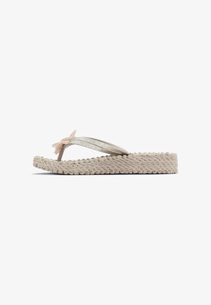Beige teenslipper met geweven plateauzool, glinsterende bandjes en een decoratieve stoffen bloem bovenop.