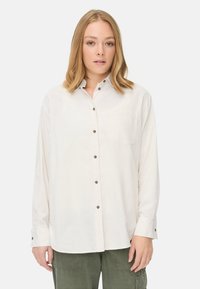 Lange mouwen, off-white knoopshirt van katoen met een borstzak en bruine knopen, met een losse pasvorm en opgerolde mouwen.