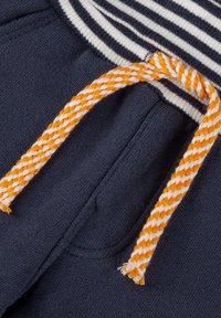 Marinefarbene Jogginghosen mit einem gestreiften Bund, ausgestattet mit einem orange-weißen geflochtenen Kordelzug und weichem Material. Zwei seitliche Taschen sind sichtbar.
