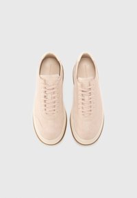 Sneakers in suede rosa chiaro con linguetta in pelle liscia, punta rotonda, design con lacci e suola in gomma bianca sottile. Stile minimalista.