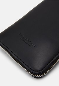 Portafoglio in pelle nera con finitura texture, dotato di una cerniera argentata e del logo "SEIDENFELT" impresso sul davanti.