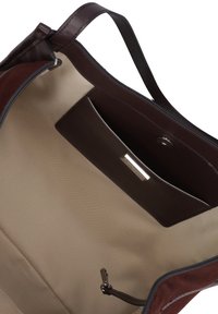 Borsa a tracolla in pelle marrone con un accento in camoscio, fodera interna beige e tasca con zip; presenta una texture liscia e un design minimalista.