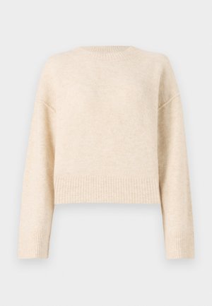 Beige strikkegenser med rund hals, kort design, ribbestrikket kant og lange ermer. Myk tekstur, lett materiale.
