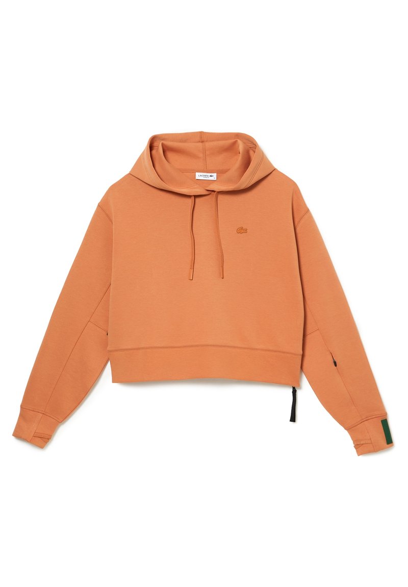 Kratší kapucí v rustikálně oranžové barvě s šňůrkou, dlouhými rukávy, malým krokodýlím logem na prsou a otvory pro palce.