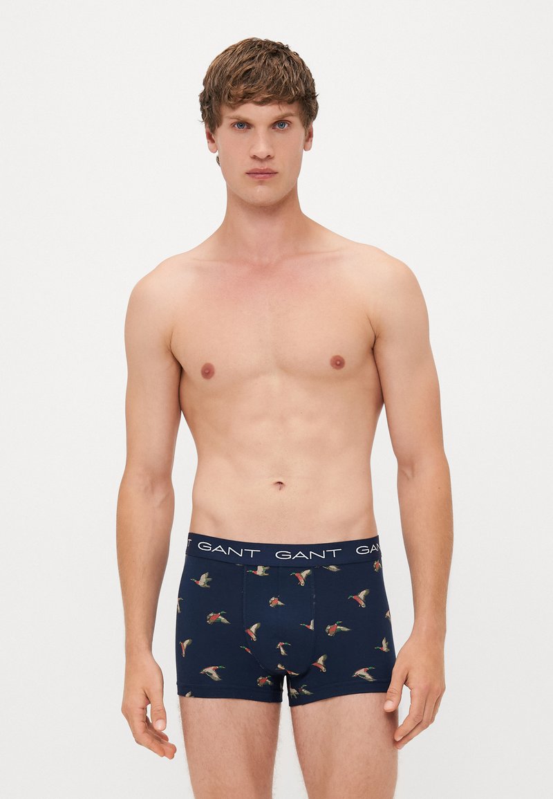 Marineblaue Boxershorts mit einem Blumen- und Vogelmuster; aus weichem Stoff mit einem elastischen Bund, der den Markennamen trägt.