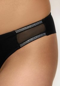 Parte inferior de bikini negra con un panel de malla transparente y adornos a lo largo de la cintura, que resalta su textura suave y ajuste preciso.