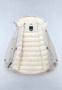 Chaqueta acolchada gris claro con capucha, que presenta una suave capa exterior y un interior aislante en color crema con acolchado en forma de rombos. Etiqueta negra en el interior.