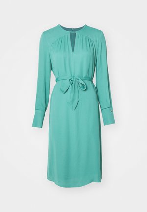 Robe longue turquoise à manches longues avec un décolleté en trou de serrure, taille à nouer et poignets boutonnés. Tissu lisse avec une silhouette légèrement drapée.