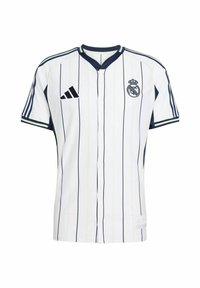 Top deportivo blanco con rayas verticales en azul marino, cierre de botones en la parte delantera, cuello redondo, logo de Adidas y escudo del Real Madrid en el lado izquierdo del pecho.