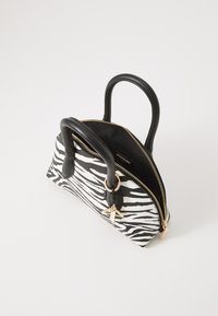 Borsa a mano piccola con stampa zebrina bianca e nera, manici neri arrotondati, cerniera dorata parzialmente aperta e charm a forma di appendino dorato.