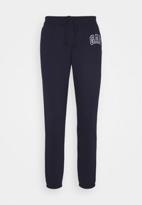 Mörkblå sweatpants i bomullsblandning med dragsko i midjan, elastiska muddar och "GAP"-logotyp i vit sömnad på vänster lår.