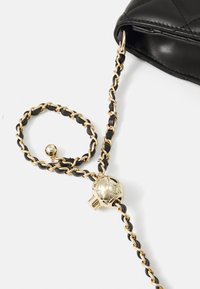 Borsa a tracolla in pelle trapuntata nera con una cinghia a catena oro e nera, caratterizzata da un accento in metallo dorato rotondo e link intrecciati.