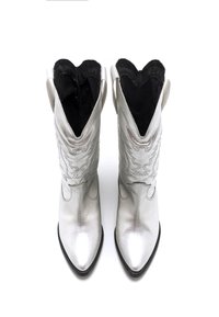 Botas de vaquero plateadas con punta puntiaguda, cuero texturizado y costuras decorativas. Diseño elegante, con una abertura amplia en la parte superior.