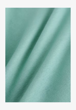 Vaalea merensinisen sävyinen kangas, jossa on sileä koostumus ja hienovaraiset hienot kudoskuviot, jotka muodostavat pehmeitä taitoksia pinnalle.