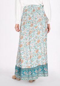 Maxi nederdel i letvægtsstof med et blomsterprint i fersken, turkis og grønnuancer. Smocket talje og mønstret kantdetalje.