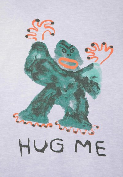 Gorille dessin animé vert avec les mains et les pieds orange levés, visage en colère, et texte en dessous indiquant "HUG ME" sur un fond clair.